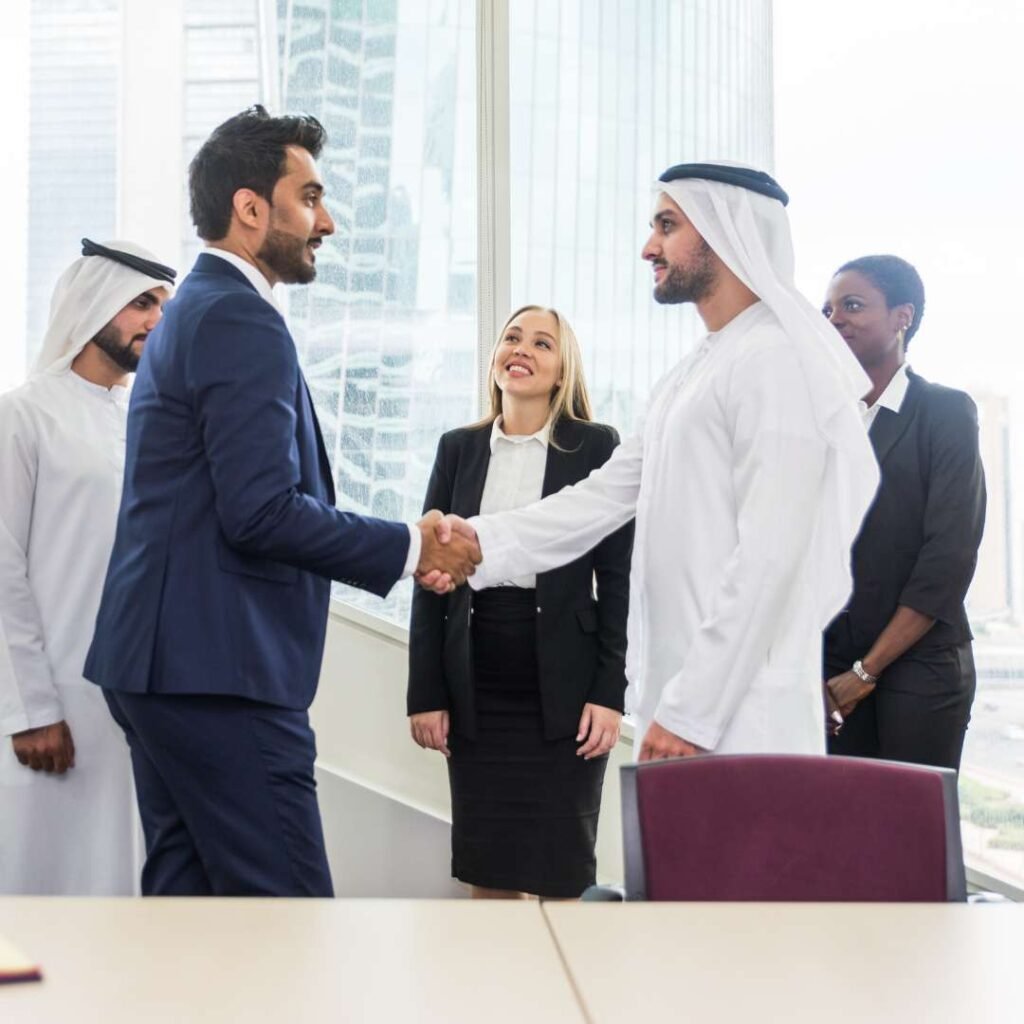 Business professionals in the UAE shaking hands during a corporate meeting, representing trusted business setup, travel, and visa consultancy services by Gulliver Travels.